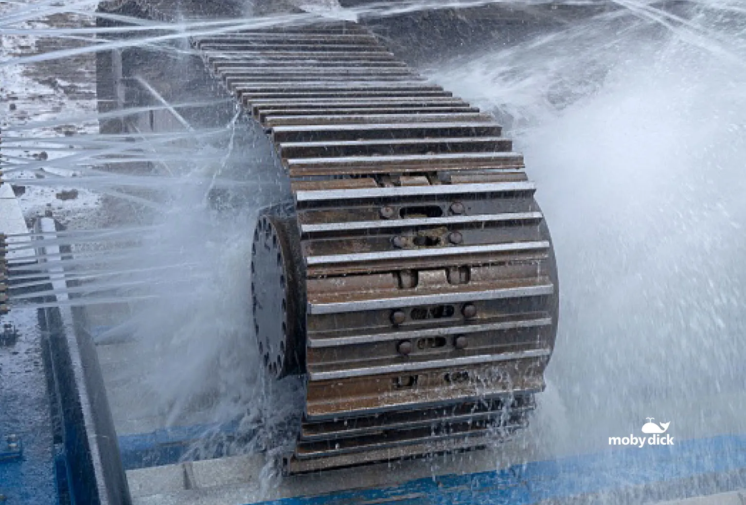 High-pressure spray cleaning an excavator track in the plant hire demucking system