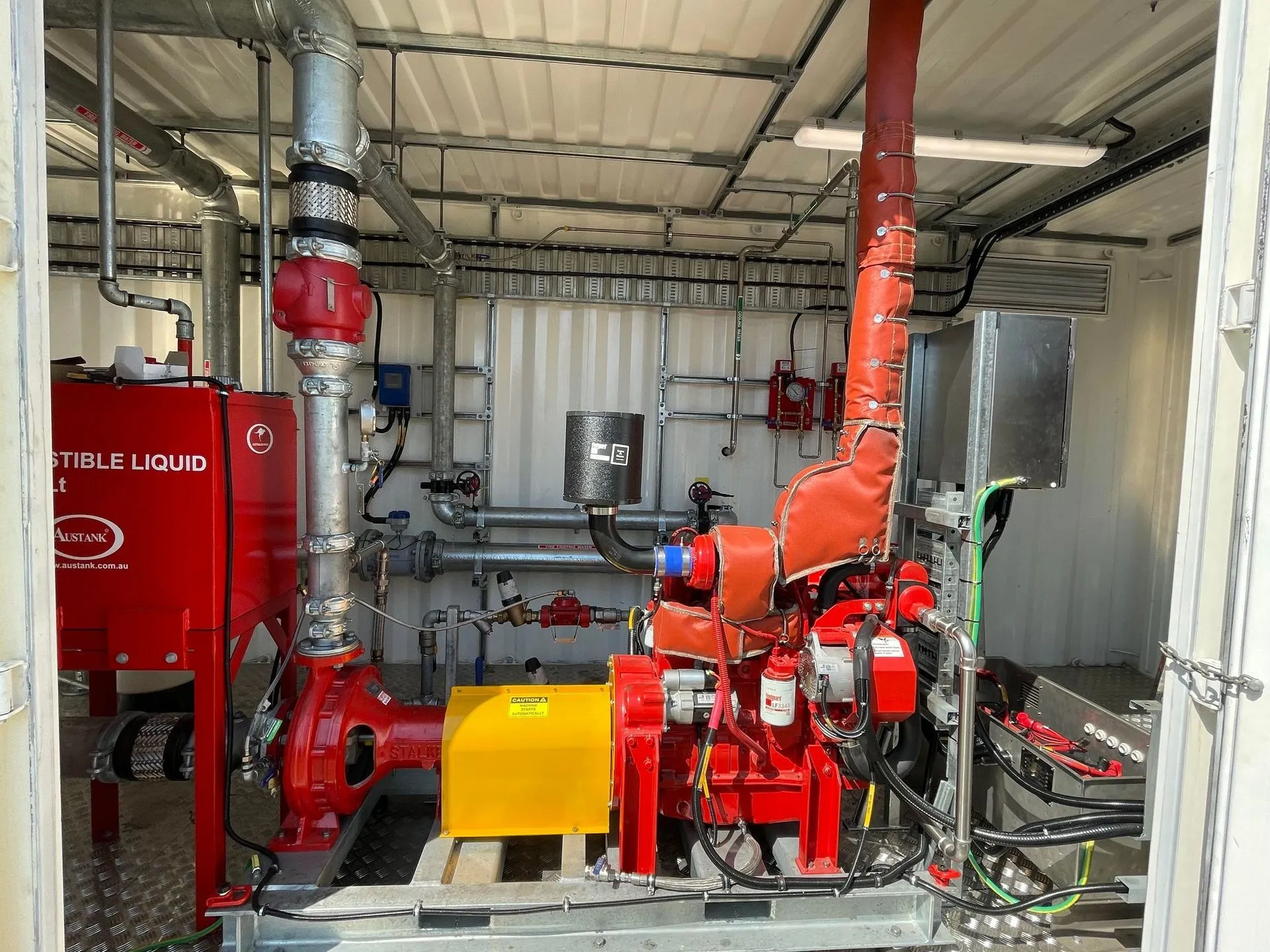 Diesel fire pumpset and red pipework inside the 40 ft container at Mt Thorley fire pump station, NSW