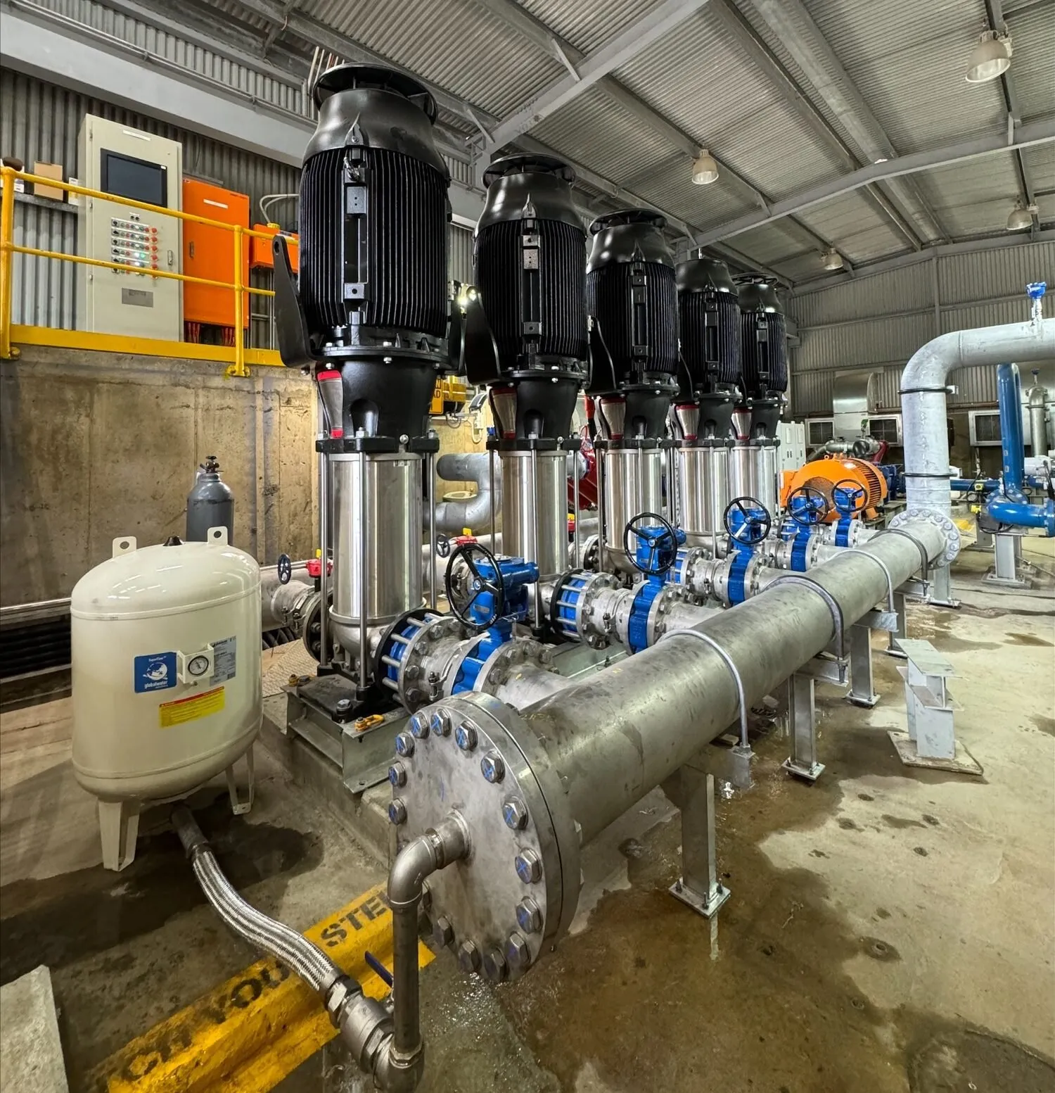 Vertical multistage high-pressure booster pump station with manifold pipework in a pump room